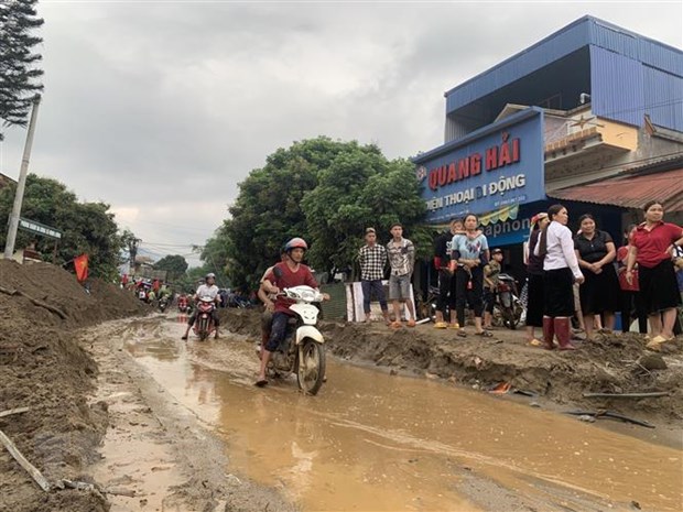 Bùn đất theo lũ trôi về tràn ngập trên Quốc lộ 279 thuộc địa phận Lào Cai. (Ảnh Hồng Ninh/TTXVN)
