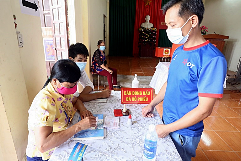Cử tri khu vực bỏ phiếu số 3, thị trấn Liễn Sơn, huyện Lập Thạch lấy giấy xác nhận đã thực hiện quyền công dân.