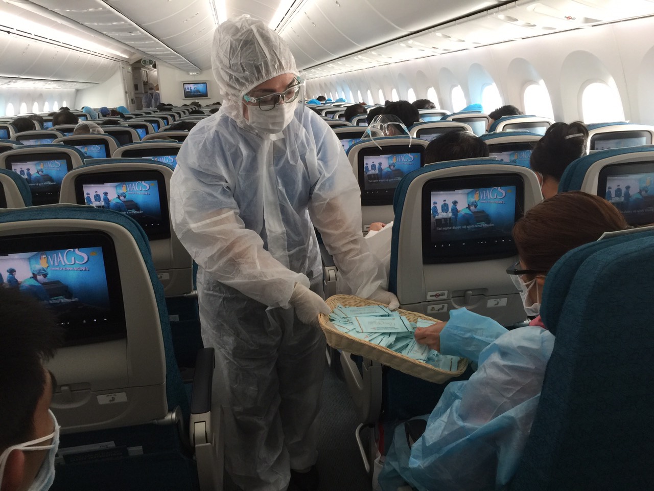 Tiếp viên Vietnam Airlines cung cấp khăn lau tay kháng khuẩn chứa cồn cho hành khách để tăng cường sát khuẩn
