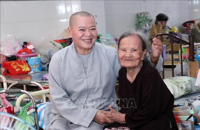 	Ni sư Thích Nữ Huệ Tuyến với cụ già đang sống tại chùa Lâm Quang - Nguồn: TTXVN