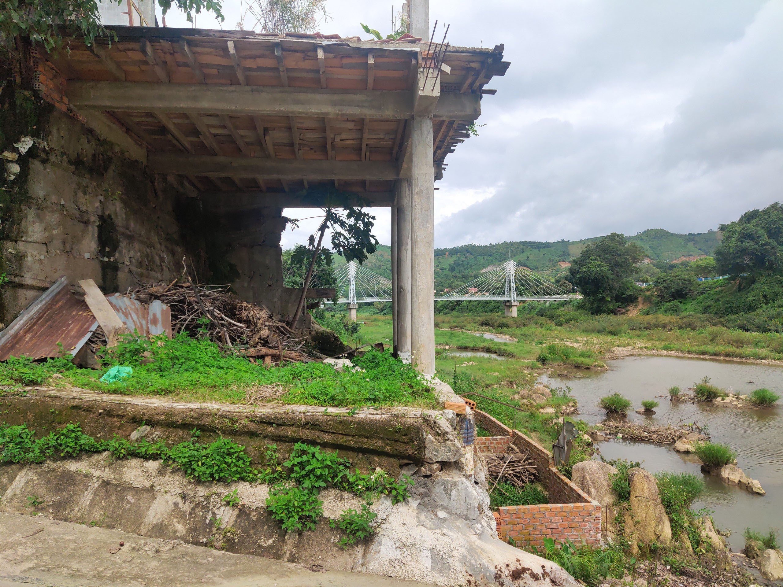 Bờ sông Đăk Pne, huyện Kon Rẫy, sạt lở nghiêm trọng, ăn sâu vào móng nhà hộ dân sinh sống ven sông - Ảnh: Dư Toán