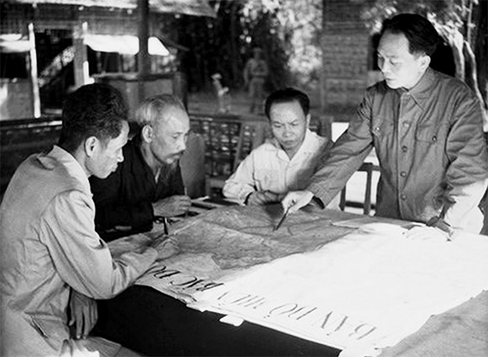Đại tướng Võ Nguyên Giáp (đứng bên phải) trình bày với Chủ tịch Hồ Chí Minh và các đồng chí lãnh đạo Đảng, Nhà nước kế hoạch mở chiến dịch Điện Biên Phủ - Nguồn: tuyengiao.vn
