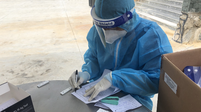 Tổ công tác lấy mẫu test nhanh kháng nguyên đang đối soát thông tin dữ liệu người dân với kết quả mẫu bệnh phẩm trong chiến dịch “hai trong một” tại phường Tân Bình, TP. Dĩ An.