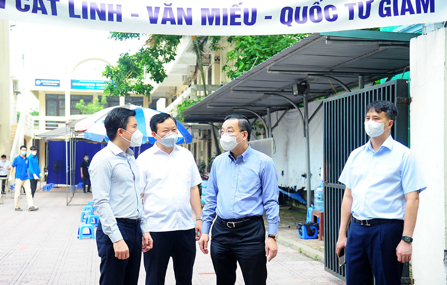 Chủ tịch UBND thành phố Hà Nội Chu Ngọc Anh trao đổi với lãnh đạo quận Đống Đa sau khi kiểm tra điểm tiêm vắc xin phòng Covid-19 tại phố Trịnh Hoài Đức.