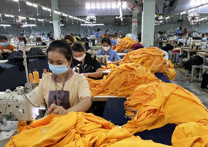 Công nhân nhà máy dệt may Thành Công sản xuất khi thực hiện phương án "3 tại chỗ". Ảnh: VNE