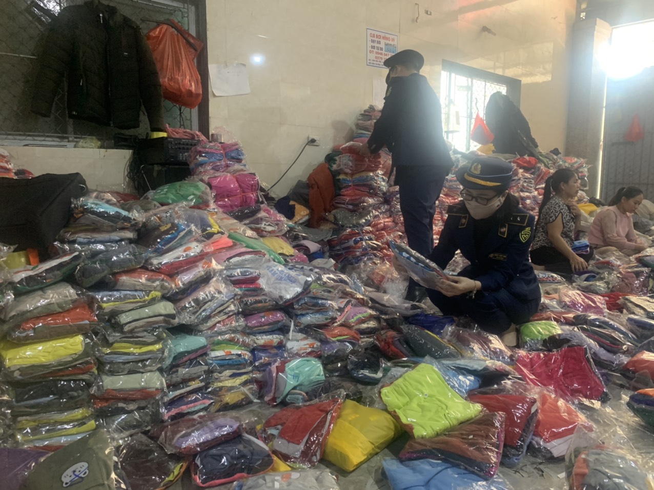 Cán bộ Quản lý thị trường Nghệ An đang kiểm tra số quần áo vi phạm