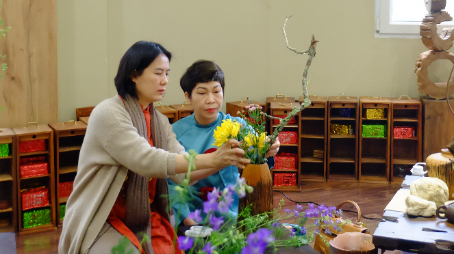 	Nghệ nhân Nguyễn Thị Thanh Hiền (trái) hướng dẫn học viên cắm hoa Tết