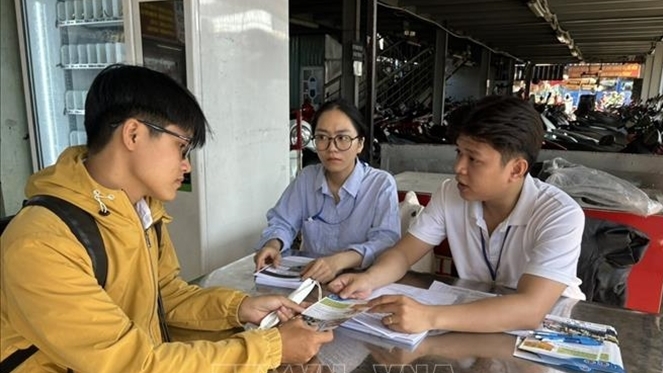 Người lao động tìm việc tại quầy tuyển dụng của Trung tâm dịch vụ việc làm TP. Hồ Chí Minh ở Bến xe An Sương. Ảnh: Thanh Vũ - TTXVN