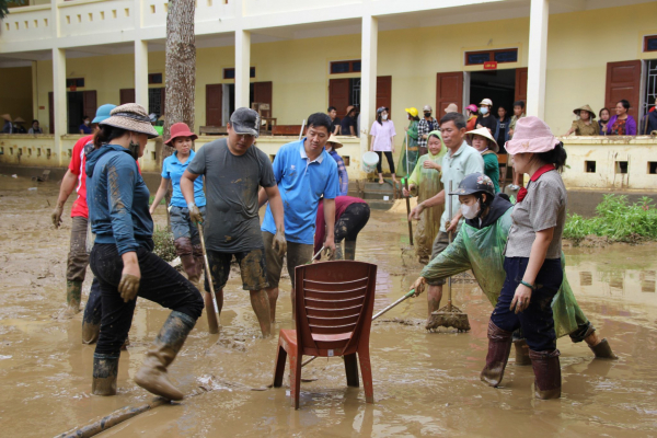 Nỗ lực dọn dẹp bùn đất sau mưa lũ - Ảnh: Việt Hòa