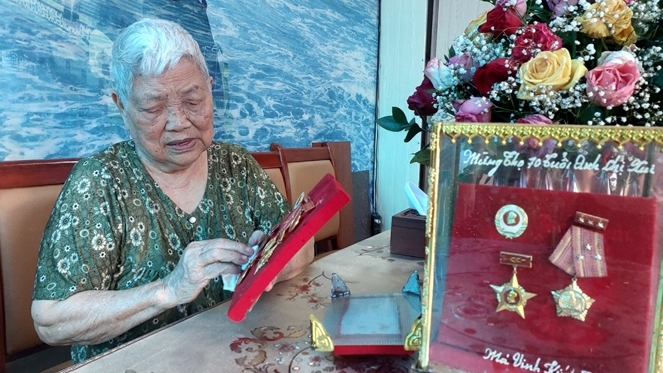 Bà Đinh Thị Thoa xem lại các kỷ vật gắn với những ngày tháng gian khổ mà hào hùng